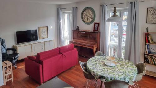 a living room with a red couch and a table at Vista sulla marina, AC, ascensore in Savona