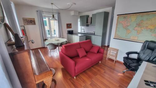 a living room with a red couch and a kitchen at Vista sulla marina, AC, ascensore in Savona