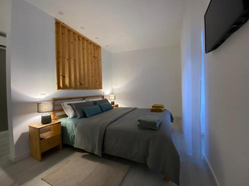 a bedroom with a bed with a wooden headboard at Urban 44 Guest House in Ponta Delgada