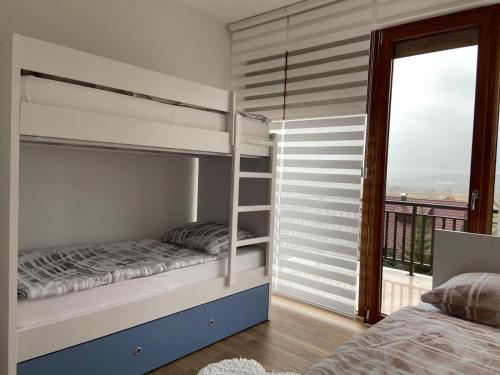 a bedroom with two bunk beds and a balcony at Apartman Anđela in Kupres