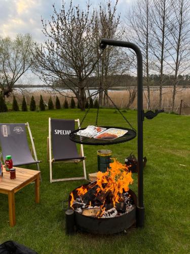 a fire pit with a table and a grill at Aparatment dla 4 osób numer 1 in Orzysz