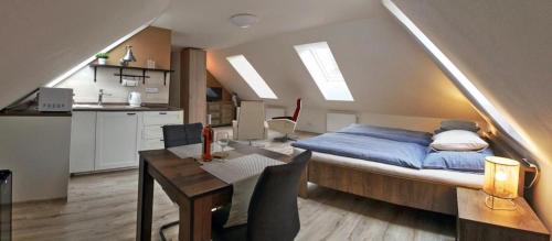 um quarto com uma cama, uma mesa e uma cozinha em Pension Kotva em Beroun