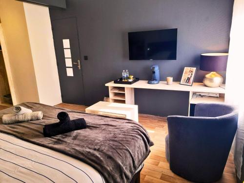 a bedroom with a bed and a desk with a tv at Le Beau Séjour 1 - Très Elégant - Proche Aéroport in Beauvais