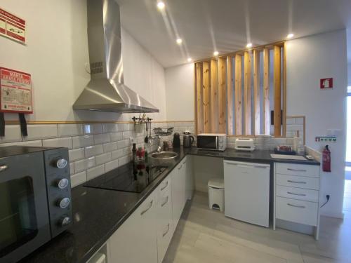 a kitchen with a sink and a microwave at Urban 44 Guest House in Ponta Delgada
