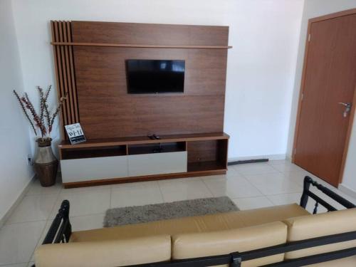 a living room with a flat screen tv on a wall at Ótimo Apartamento São Lourenço in São Lourenço