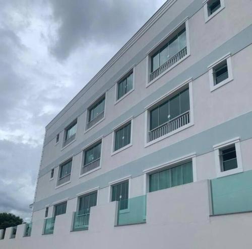 um edifício branco com janelas do lado em Ótimo Apartamento São Lourenço em São Lourenço