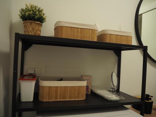 a black shelf with baskets and a mirror at Apartment Simon in Zagreb