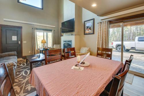a dining room with a table and a living room at Spacious Sturgis Cabin with Grill and Wraparound Patio in Sturgis
