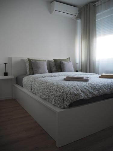 a white bedroom with a large bed with a window at Apartment Simon in Zagreb
