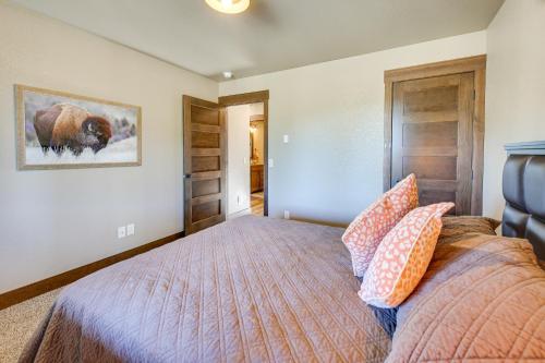a bedroom with a bed with pillows on it at Spacious Sturgis Cabin with Grill and Wraparound Patio in Sturgis