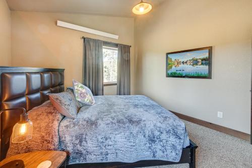 a bedroom with a bed with a blue comforter at Spacious Sturgis Cabin with Grill and Wraparound Patio in Sturgis
