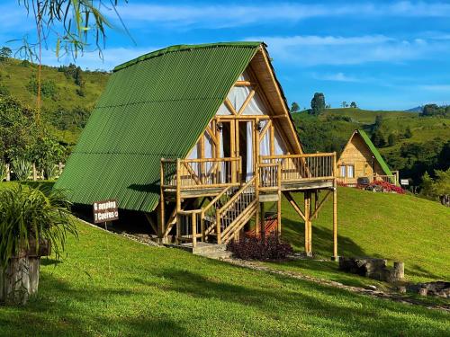 Casa de madera grande con techo verde en Glamping La Herradura, en Santa Rosa de Cabal