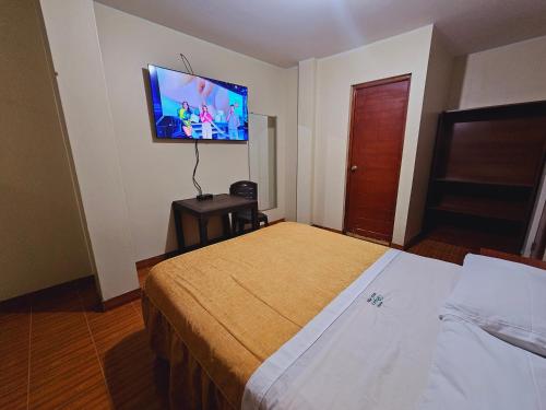 a hotel room with a bed and a tv on the wall at HOSTAL VEGA'S NAZCA in Nazca