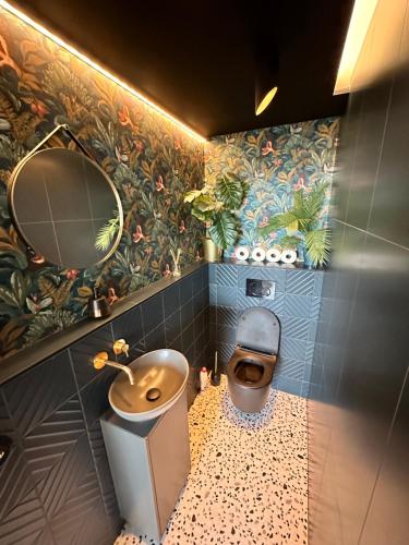 La salle de bains est pourvue de toilettes, d'un lavabo et d'un miroir. dans l'établissement Skyline elegance with free parking, à Bratislava