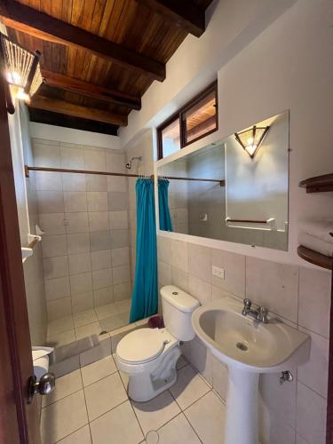 y baño con aseo y lavamanos. en Victor Hugo Hotel, en Puerto López