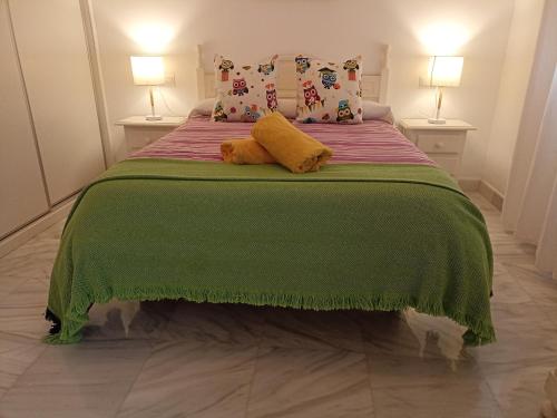 a bedroom with a green bed with two lamps at Apartamento Exclusivo - María 7 in Benaoján