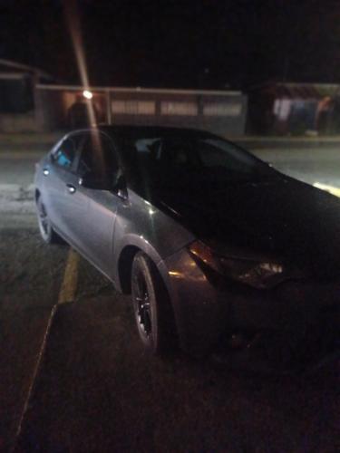 une voiture en argent garée sur un parking la nuit dans l'établissement Renta Cars Tela, à Tela