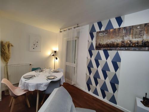 a dining room with a table and a blue and white wall at QuietStay 20' PARIS, Connected HOME avec Terrasse in Massy