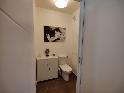 baño con aseo y una foto en la pared en QuietStay 20' PARIS, Connected HOME avec Terrasse, en Massy