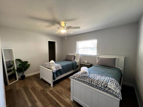 a bedroom with two beds and a ceiling fan at New! Fully Renovated 3/2 Luxury Vacation Home in Venice