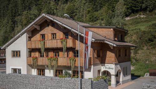 a building with flowers on the balconies of it at Hotel Pension Wilma in Schruns