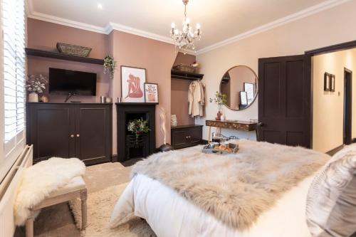 a bedroom with a large white bed and a mirror at Boutique luxury Stratford Townhouse- beautifully renovated sleeps upto 4 - free parking - minutes walk to theatres, town & pubs in Stratford-upon-Avon