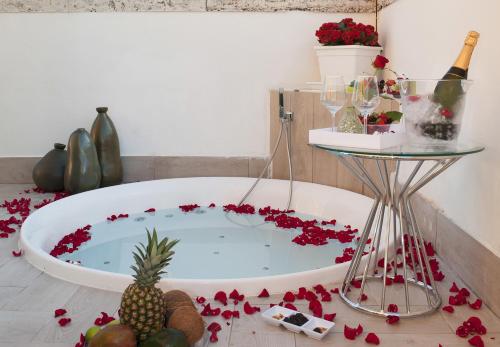 a bath tub filled with red flowers and a pineapple at Terrazza Marco Antonio Luxury Suite in Rome