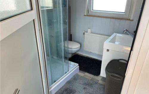 a bathroom with a toilet and a glass shower at Cozy Chalet in Camping 't Venhop in Berkhout