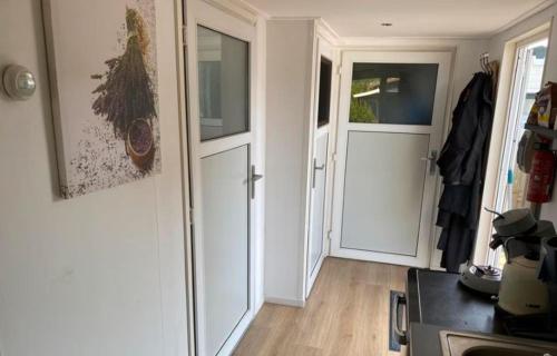 a hallway with two white doors in a room at Cozy Chalet in Camping 't Venhop in Berkhout