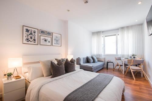 een witte slaapkamer met een bed en een woonkamer bij Inmejorable Ubicación en Madrid in Madrid