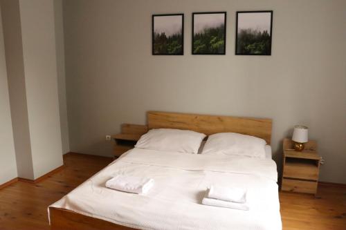 - une chambre avec un lit blanc et trois photos sur le mur dans l'établissement Okno na Śnieżkę, à Karpacz