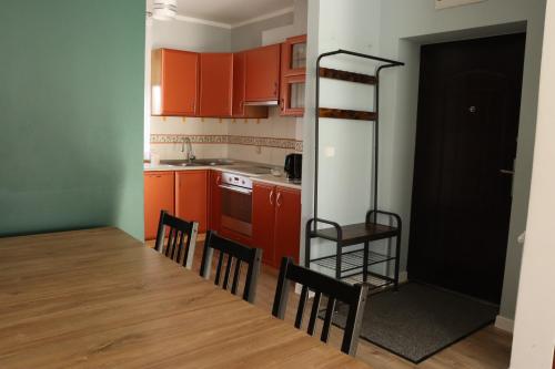 une cuisine avec des placards rouges, une table et des chaises dans l'établissement Okno na Śnieżkę, à Karpacz