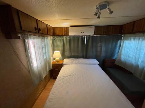 Dormitorio pequeño con cama y lámpara en casa movil en Playa Paraiso
