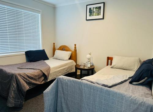a room with two beds and a window at Papamoa B&B in Papamoa
