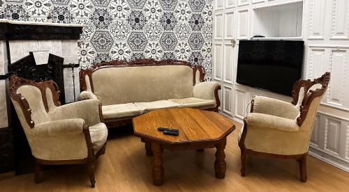 sala de estar con 2 sillas, mesa y TV en KING Apartments in city centre, en Leópolis