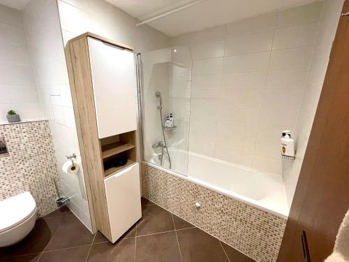 y baño con ducha, bañera y aseo. en The Dawn Towers Apartment Žižkov en Praga