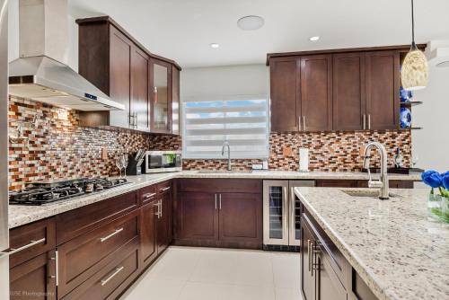 a kitchen with wooden cabinets and marble counter tops at Peaceful Rental Retreat in Miami Jacuzzi, BBQ L25 in Hialeah