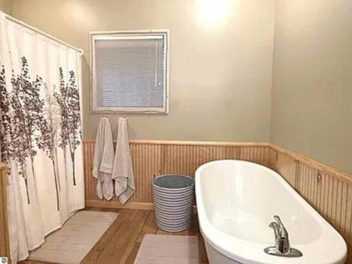 a bathroom with a bath tub and a sink at Spacious condo for 6 on Golf course, Pool Pass in Bellaire