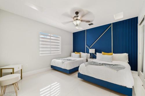 Un dormitorio con 2 camas y una pared de acento azul en Peaceful Rental Retreat in Miami Jacuzzi, BBQ L25, en Hialeah