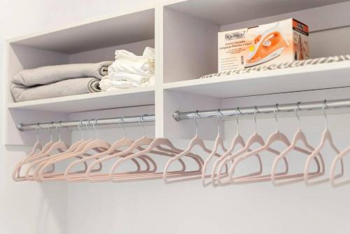 a walk in closet with white shelves and towels at Elegant Bd,EWR AIRPT,Nyc, Free Pkng, Prudential CNTR, American Dream Mall in Elizabeth
