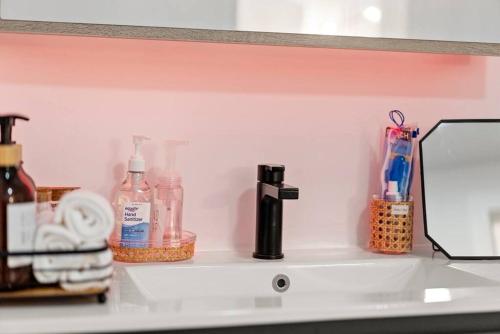 um balcão de casa de banho com artigos de higiene numa prateleira em Elegant Bd,EWR AIRPT,Nyc, Free Pkng, Prudential CNTR, American Dream Mall em Elizabeth