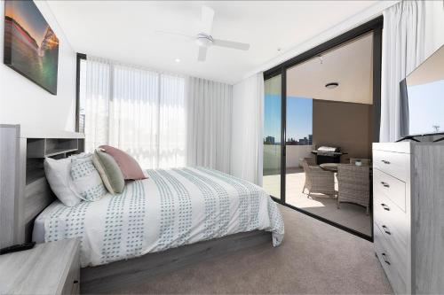 a bedroom with a bed and a sliding glass door at Solaris 312 in Forster