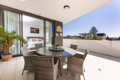 a dining room with a table and chairs and a bedroom at Solaris 312 in Forster