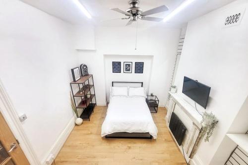 a white room with a bed and a tv at 'TheFive' Camden Town in London