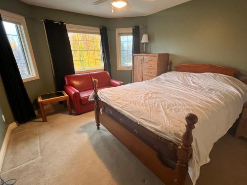 a bedroom with a bed and a chair and windows at Youth hostel 2 in Calgary
