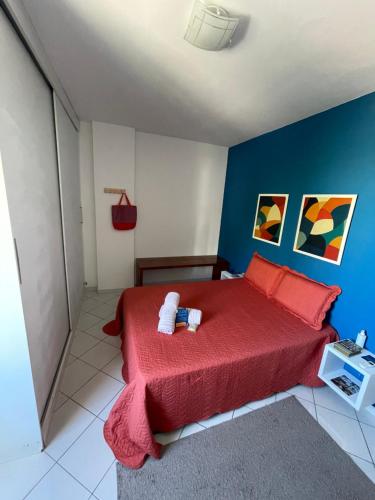 a bedroom with a red bed and blue walls at Apartamento Auge da Bahia in Salvador