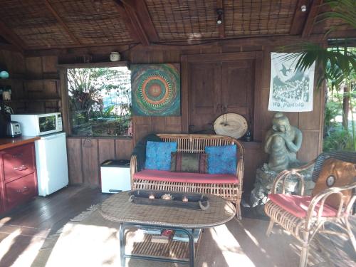 ein Wohnzimmer mit einem Sofa und einem Tisch in der Unterkunft The Bali Room in Coromandel Town