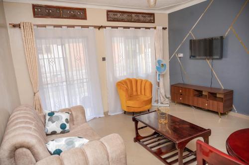 uma sala de estar com um sofá e uma televisão em Macky cottages em Kampala