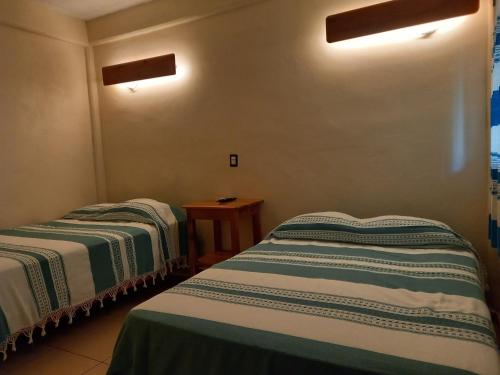 Zimmer mit 2 Betten und einem Tisch in der Unterkunft Hniu Li Valle Nacional in San Juan Bautista Valle Nacional