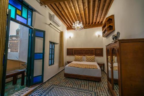 um quarto com uma cama e um vitral em Dar Usham Fes em Fez